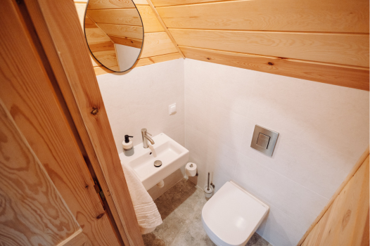 Toaleta wykończona jasnymi płytkami.